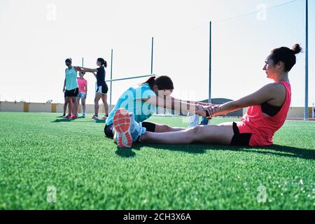 group of young women practice stretching after their training Stock Photo