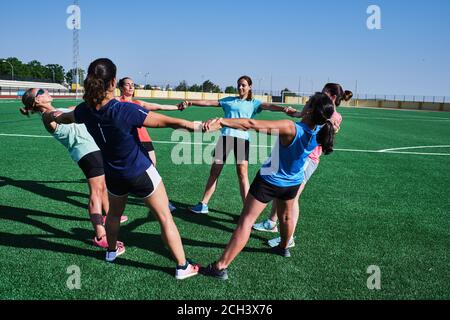group of young women practice stretching after their training Stock Photo