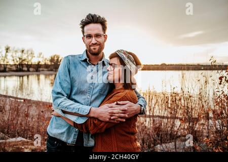 Happy couple hugging near a lake in Denver CO on a autumn evening Stock Photo