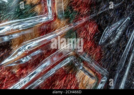 The fabric of a colorful carpet under the pressed glass as an abstract background Stock Photo
