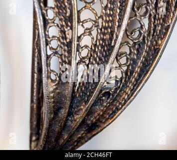 Macro view of an old metal figurine on the white background. Close up, selective focus. Stock Photo