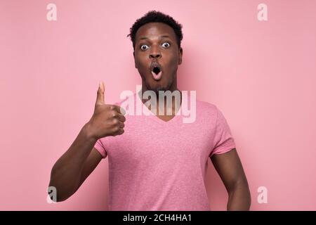Surprised handsome black man showing thumb up giving advice Stock Photo