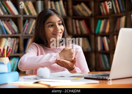 School girl learning online communicating by video call using sign language. Stock Photo
