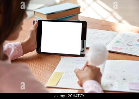 School girl learning online on digital tablet. Over shoulder mock up screen. Stock Photo