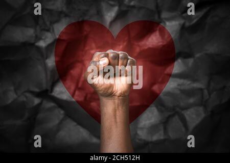 Hand of African-American man with clenched fist on dark background. Stop racism Stock Photo