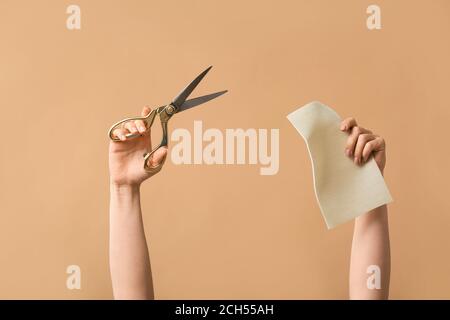 Female hands tailor's scissors and fabric on color background Stock Photo