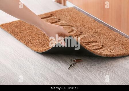 Spotlijster Voorverkoop klimaat Woman putting spare key under door mat Stock Photo - Alamy
