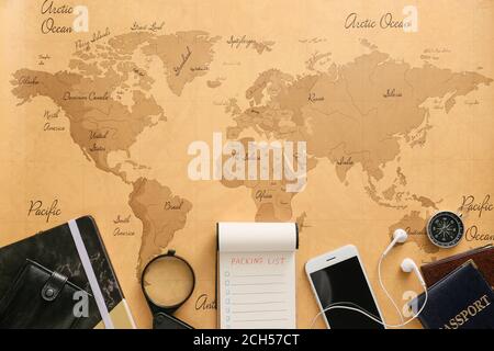 Notebook with check-list of things to pack for travel on world map Stock Photo