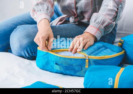 Woman packing clothes before journey at home Stock Photo