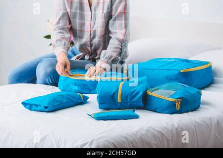 Woman packing clothes before journey at home Stock Photo