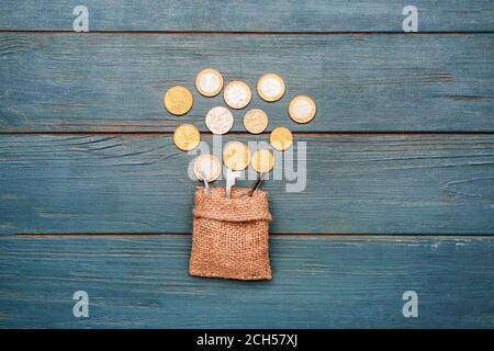 Bag with keys and coins on wooden background Stock Photo