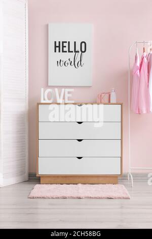 Modern chest of drawers with clothes rack near color wall in dressing room Stock Photo Alamy