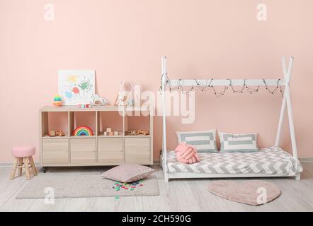 Interior of modern children's room with comfortable bed and rack with toys Stock Photo