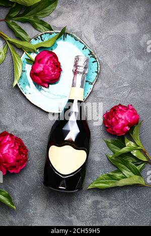 Composition with bottle of champagne and flowers on grey background Stock Photo