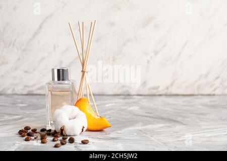 Reed diffuser on table against light background Stock Photo