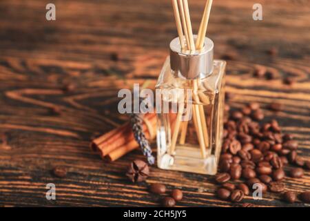 Reed diffuser with coffee beans and cinnamon on table Stock Photo