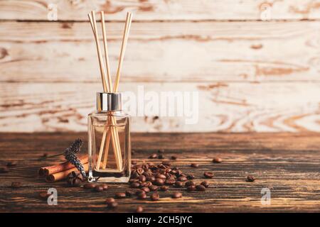 Reed diffuser with coffee beans and cinnamon on table Stock Photo