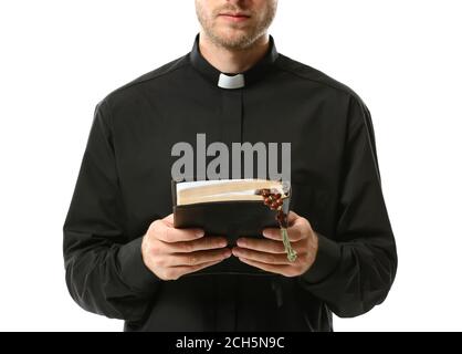 Handsome priest with Bible on white background Stock Photo