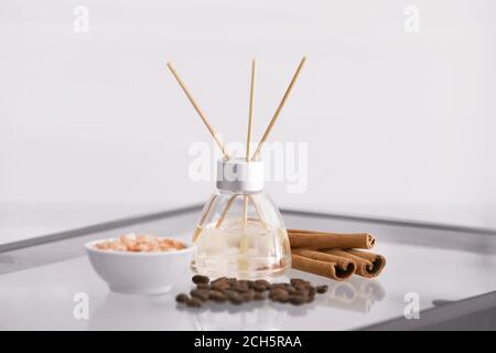 Reed diffuser, cinnamon, sea salt and coffee beans on table Stock Photo