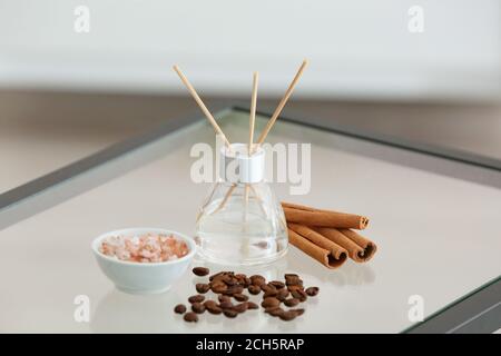 Reed diffuser, cinnamon, sea salt and coffee beans on table Stock Photo