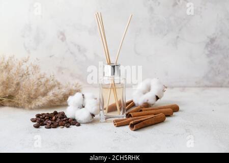 Reed diffuser, cotton, coffee beans and cinnamon on table Stock Photo
