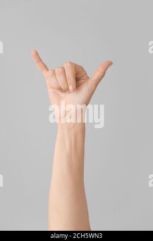 Hand showing letter Y on grey background. Sign language alphabet Stock Photo