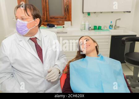 Attractive young girl waiting with trust her doc dad working on a  medical check-up. Teeth dental office . Florence Tuscany Italy Stock Photo
