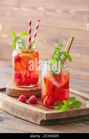 Mason jars of cold raspberry tea on table Stock Photo - Alamy