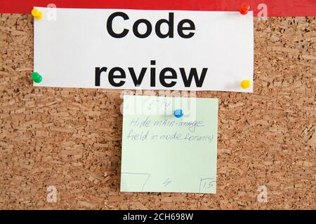 Code review section with pinned paper ticket on cork kanban board Stock Photo