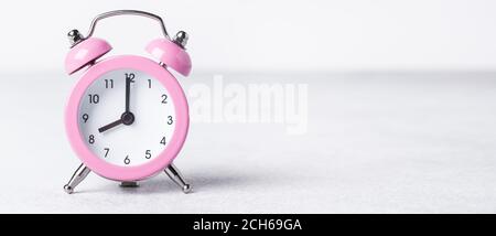 Pink alarm clock on on stone background. Copy space for text. Horizontal banner - Image Stock Photo