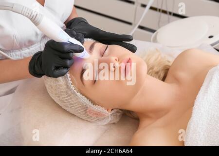Woman undergoing procedure of vacuum hydro peeling in beauty salon Stock Photo
