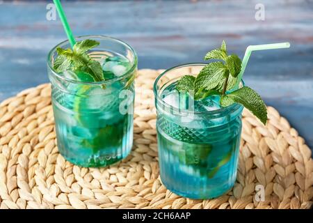 Glasses of tasty blue mojito cocktail on table Stock Photo