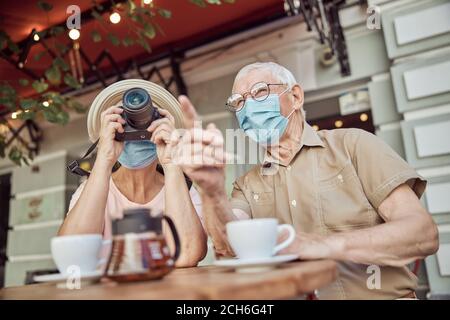 Woman in a sunhat photographing with a digital camera Stock Photo