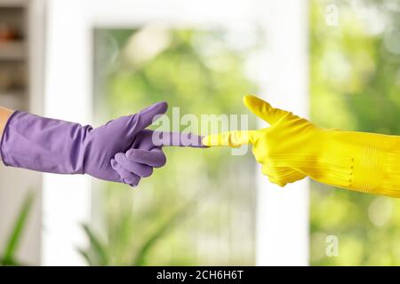 Women in rubber gloves touching fingers at home Stock Photo