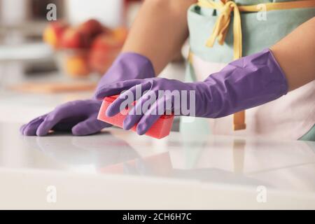 Woman in rubber gloves cleaning kitchen Stock Photo