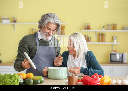 Mature couple cooking dinner at home Stock Photo