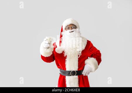 African-American Santa Claus with milk on light background