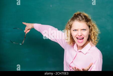Remember this. Strict woman teacher pointing at chalkboard. Informing kids. School rules. School principal stressful outraged expression. Educational system concept. School lesson knowledge. Stock Photo