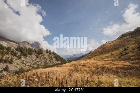 Panorama of a Alpine mountain valley and peaks. High mountain peaks and a glacier and water falls on the Italian side of the Mont Blanc Massive. Stock Photo