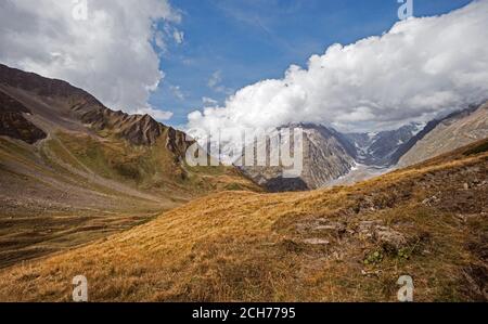 Panorama of a Alpine mountain valley and peaks. High mountain peaks and a glacier and water falls on the Italian side of the Mont Blanc Massive. Stock Photo