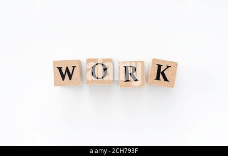 A wooden block with the word WORK written on it on a white background Stock Photo