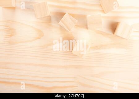 wooden cubes on a light wooden background. warm wooden background. the concept of creativity, products from natural wood, wood crafts. Stock Photo