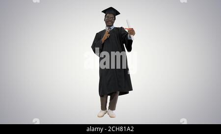 Happy african american male student in graduation robe posing wi Stock Photo