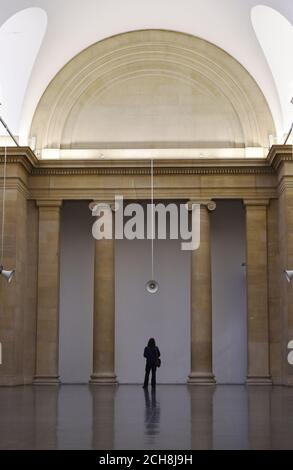 A visitor looks at a speaker, as British artist Susan Philipsz exhibits her new installation War Damaged Musical Instruments at the Tate Britain, London, which marks the First World War Centenary. Stock Photo