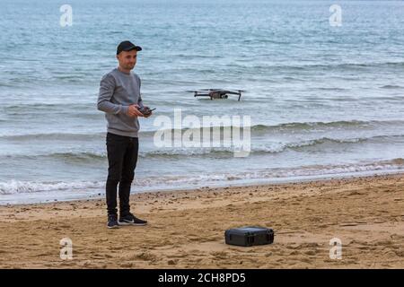Young man operating a drone at event at Bournemouth beach, Bournemouth, Dorset UK in September Stock Photo