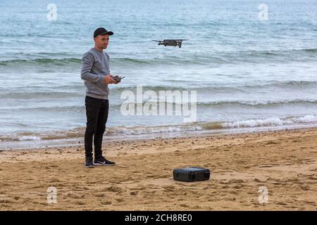 Young man operating a drone at event at Bournemouth beach, Bournemouth, Dorset UK in September Stock Photo