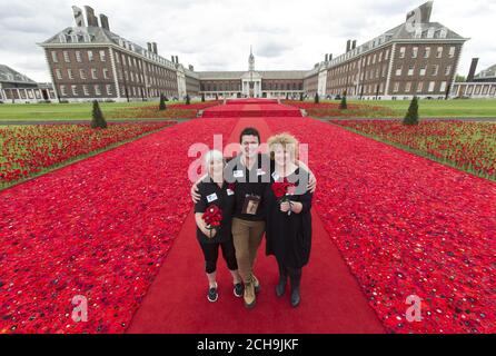 Co-creators Margaret Knight (left) and Lynn Berry with designer Philip Johnson at their 5000 Poppies exhibit - which uses almost 300,000 individually crocheted poppies, covering nearly 2,000sq m (21,000sq ft) in the grounds of the Royal Hospital Chelsea - during a preview day at the Chelsea Flower Show in London. Stock Photo