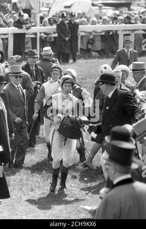 Lester Piggott walks towards the weighing room after his Derby victory on Roberto at Epsom. Still doubtful about the result after a photo finish battle with Rheingold, he had dismounted on the course instead of entering the winner's enclosure. A stewards' inquiry left the placings unaltered, and Piggott could celebrate his sixth Derby victory, equalling the all-time record. Stock Photo