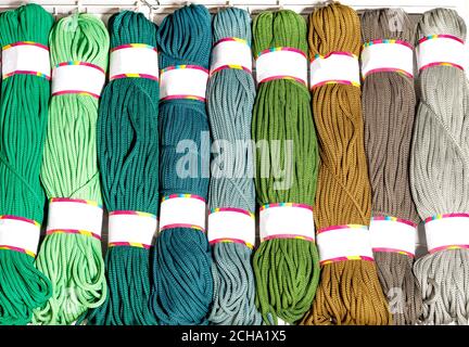 Rolls of polyester cord in various bright colors of green and beige, rolled up, close-up, copy space. Stock Photo