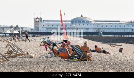 Brighton UK 14th September 2020 - Sunbathers enjoy the hot sunny weather on Brighton beach as temperatures are forecast to reach 30 degrees in parts of the South East  : Credit Simon Dack / Alamy Live News Stock Photo